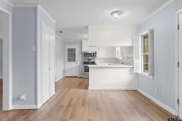 a kitchen with appliances a sink cabinets and a window