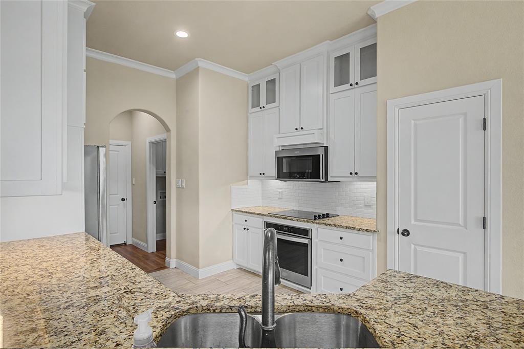 143 Wrigley Drive Springtown, TX 76082 - Photo 18 of 38 Kitchen featuring arched walkways, crown molding, a pantry, stainless steel sink and appliances.