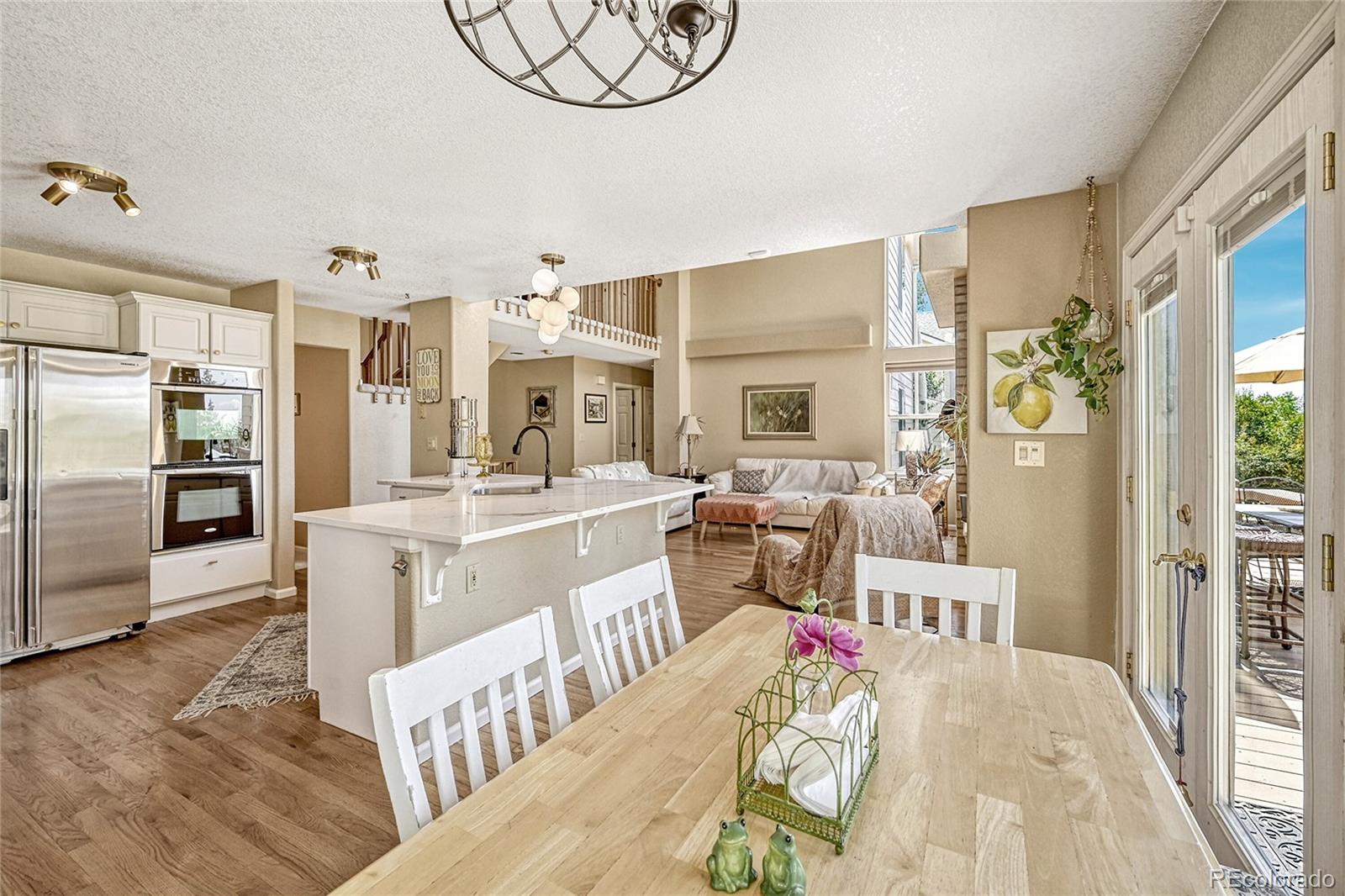 9754 Chanteclair Circle Highlands Ranch, CO 80126 - Photo 14 of 47 a living room with stainless steel appliances furniture a rug and a kitchen view