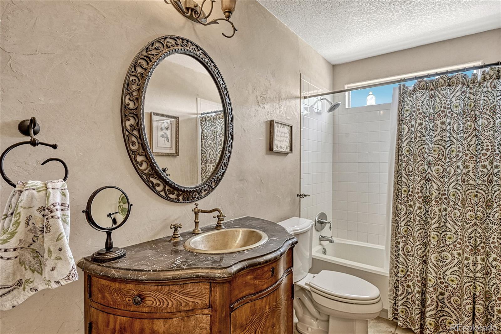 9754 Chanteclair Circle Highlands Ranch, CO 80126 - Photo 17 of 47 a bathroom with a sink a toilet and a mirror