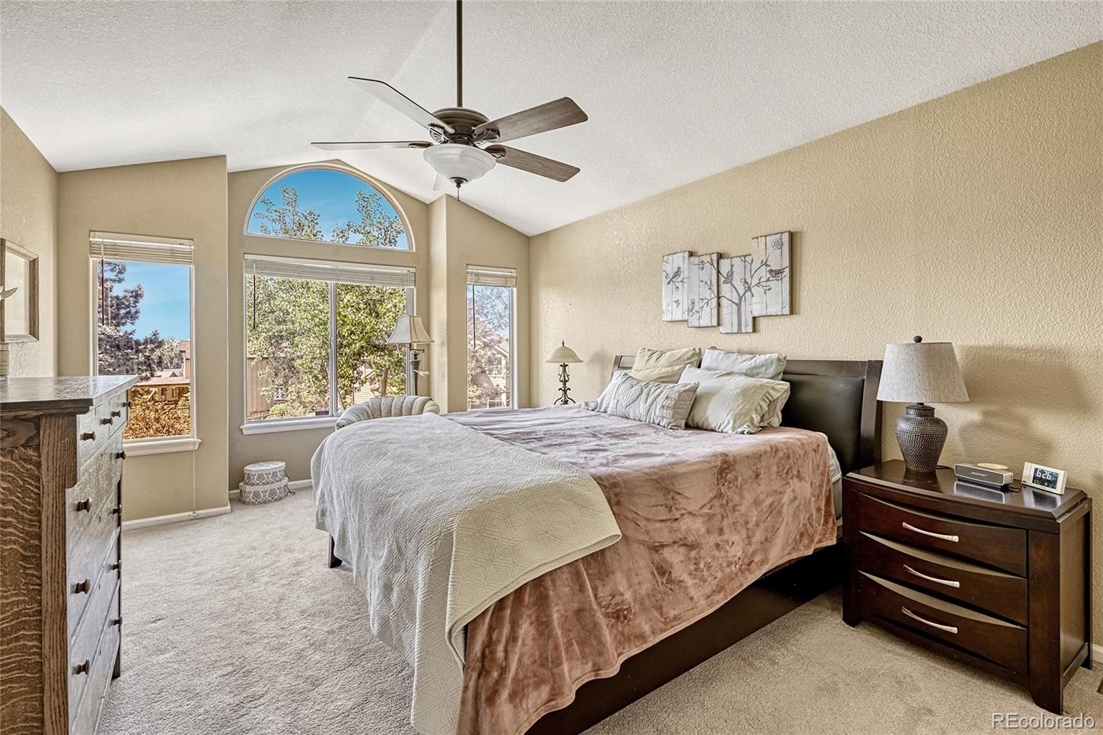 9754 Chanteclair Circle Highlands Ranch, CO 80126 - Photo 22 of 47 a spacious bedroom with a bed and a chandelier