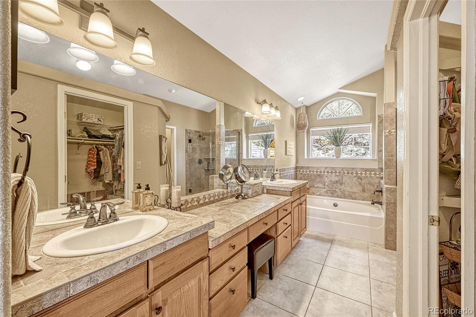 9754 Chanteclair Circle Highlands Ranch, CO 80126 - Photo 24 of 47 a bathroom with a granite countertop sink mirror and a bath tub