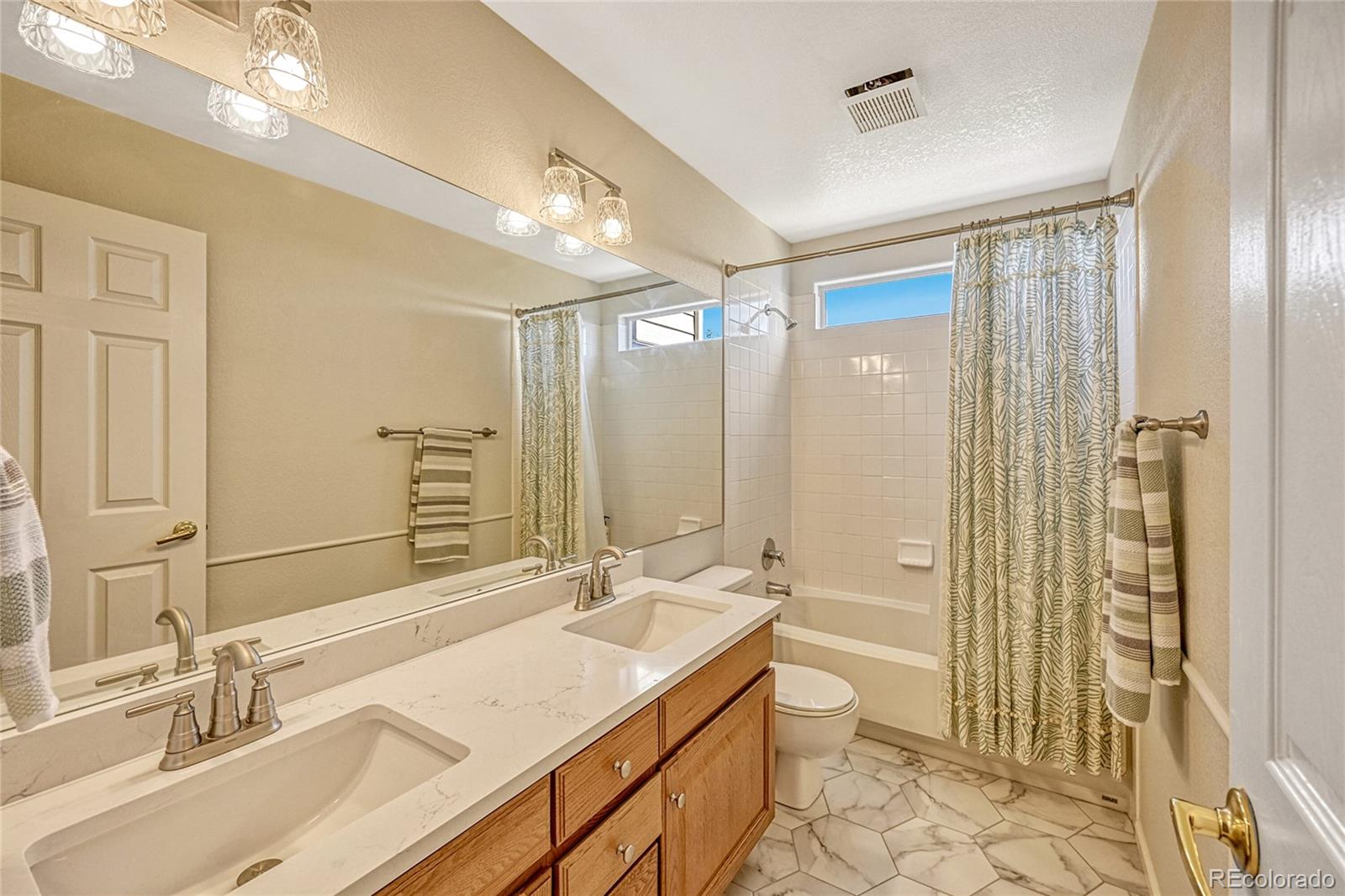 9754 Chanteclair Circle Highlands Ranch, CO 80126 - Photo 27 of 47 a bathroom with a sink double vanity granite tub shower and a mirror