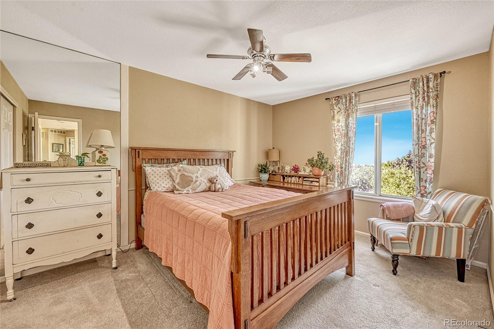 9754 Chanteclair Circle Highlands Ranch, CO 80126 - Photo 28 of 47 a bedroom with a bed and a chandelier