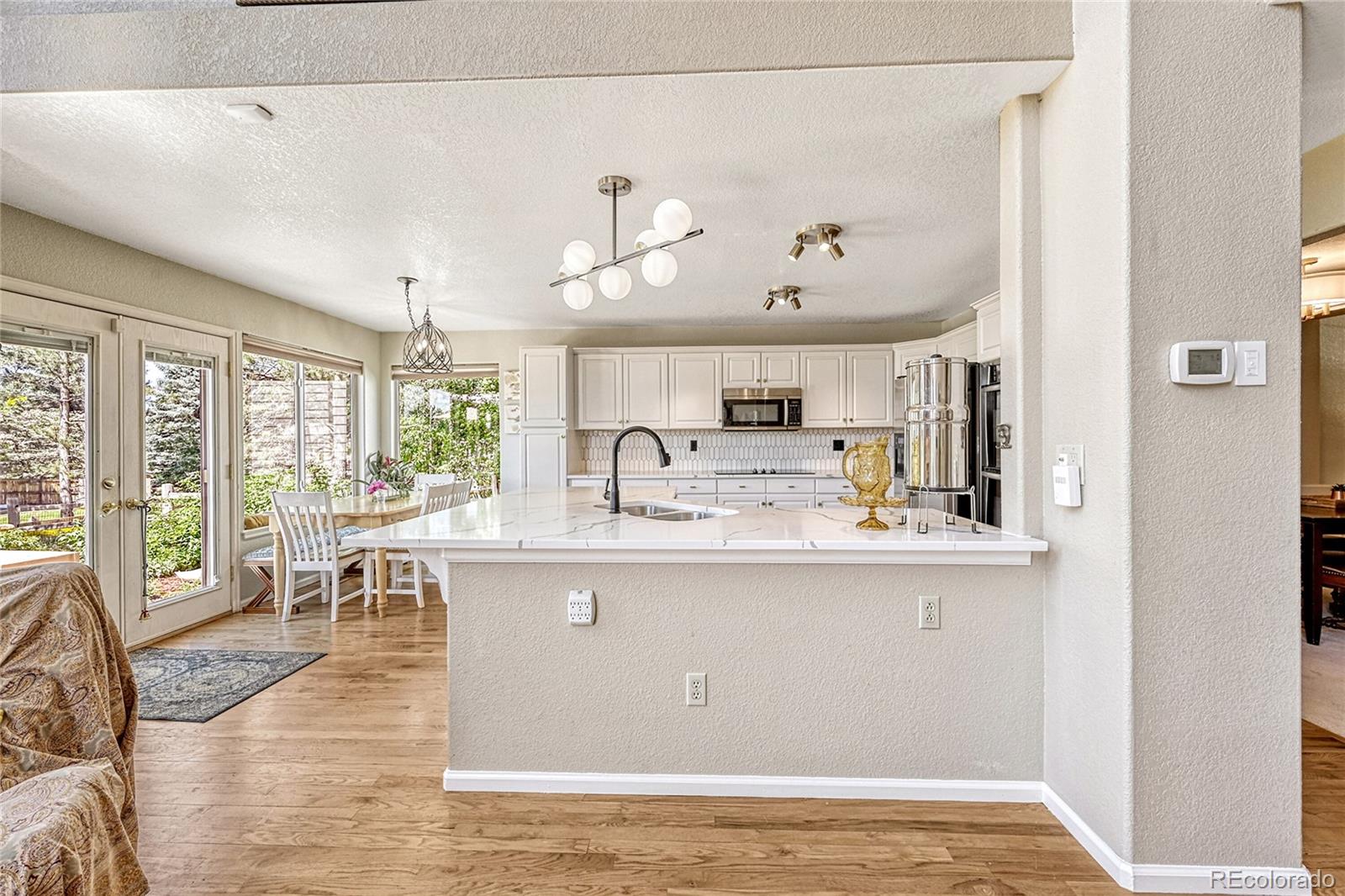 9754 Chanteclair Circle Highlands Ranch, CO 80126 - Photo 9 of 47 a living room with stainless steel appliances granite countertop furniture and a view of kitchen