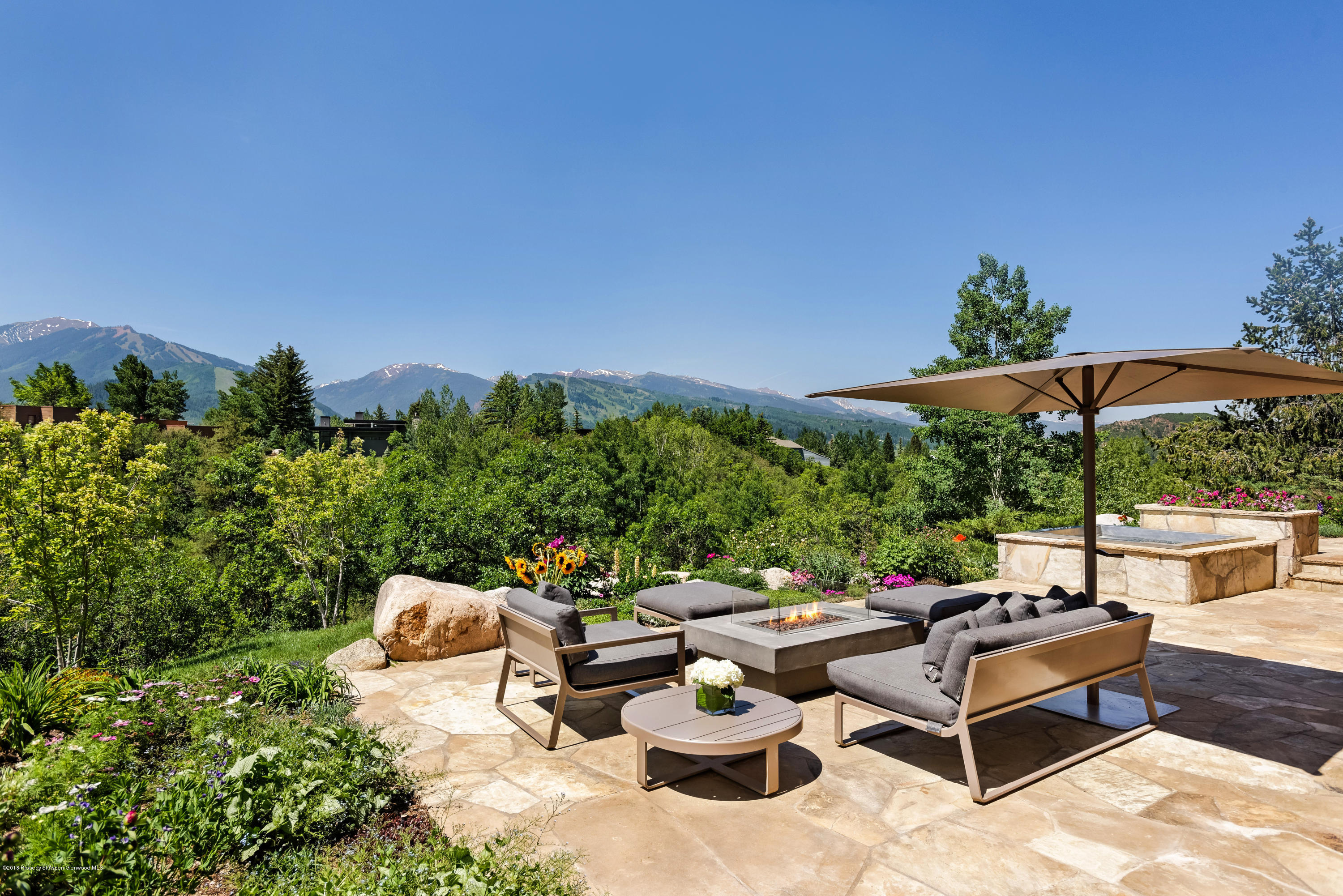 274 Draw Drive Aspen, CO 81612 - Photo 20 of 32 a view of a patio with couches and table and chairs under an umbrella