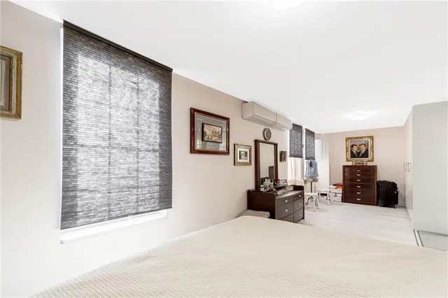 a living room with furniture a large window and dresser