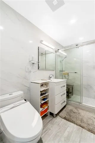 a bathroom with a sink a toilet and shower