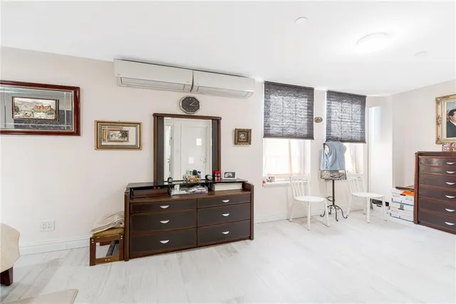 a living room with a dresser and a window