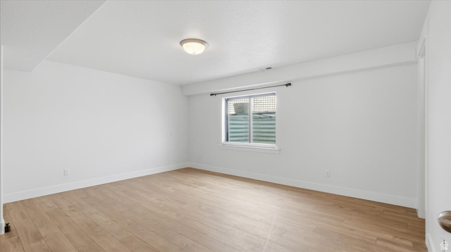 2038 East Ranch Road Eagle Mountain, UT 84005 - Photo 34 of 66 Spacious room featuring light wood-finish flooring, white walls, a flush-mount ceiling light fixture, and a window with a window well