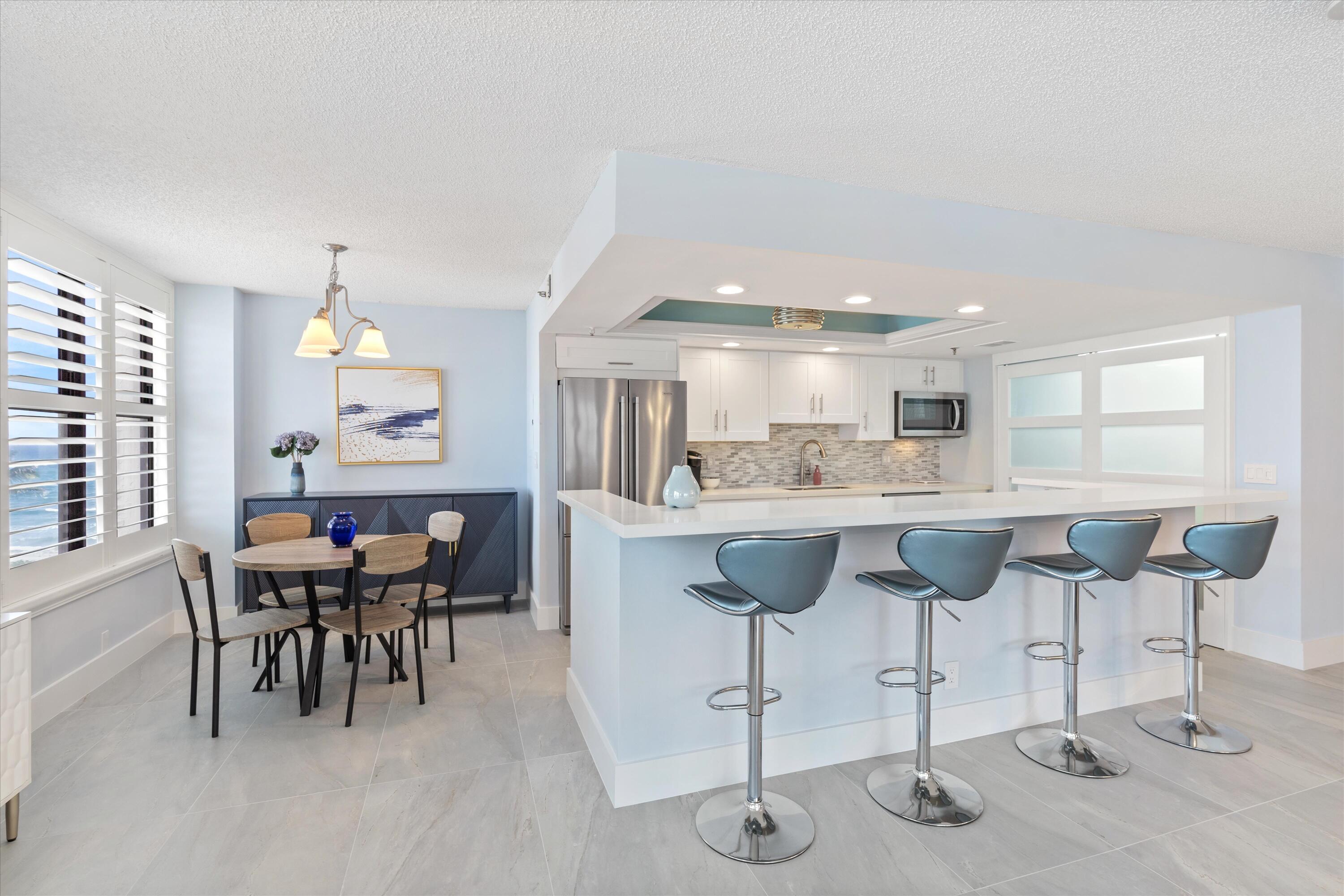 a kitchen with stainless steel appliances kitchen island granite countertop a table and chairs in it