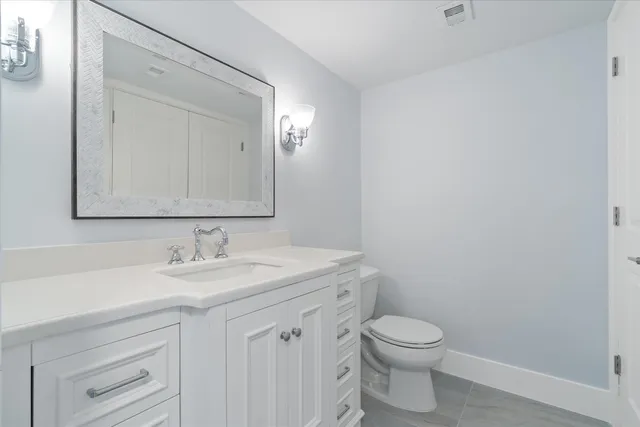 a bathroom with a toilet a sink a vanity and mirror