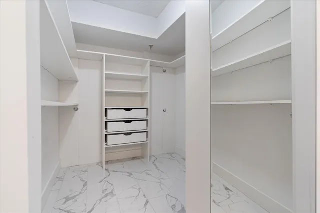 a view of walk in closet with empty racks