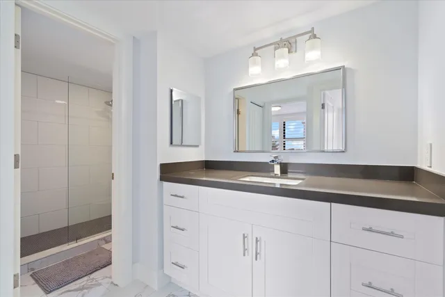 a bathroom with a granite countertop sink and a mirror