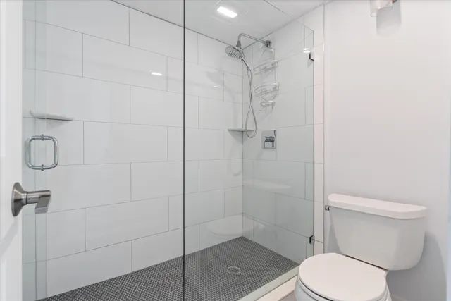 a white toilet next to a bathroom