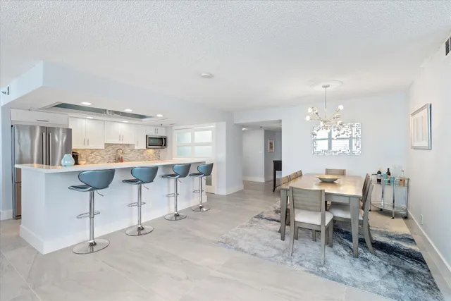 a living room with furniture and a dining table with kitchen island