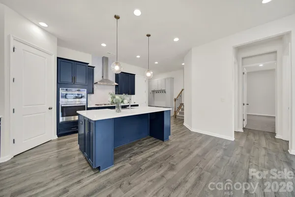 a large kitchen with stainless steel appliances wooden floor and large cabinets