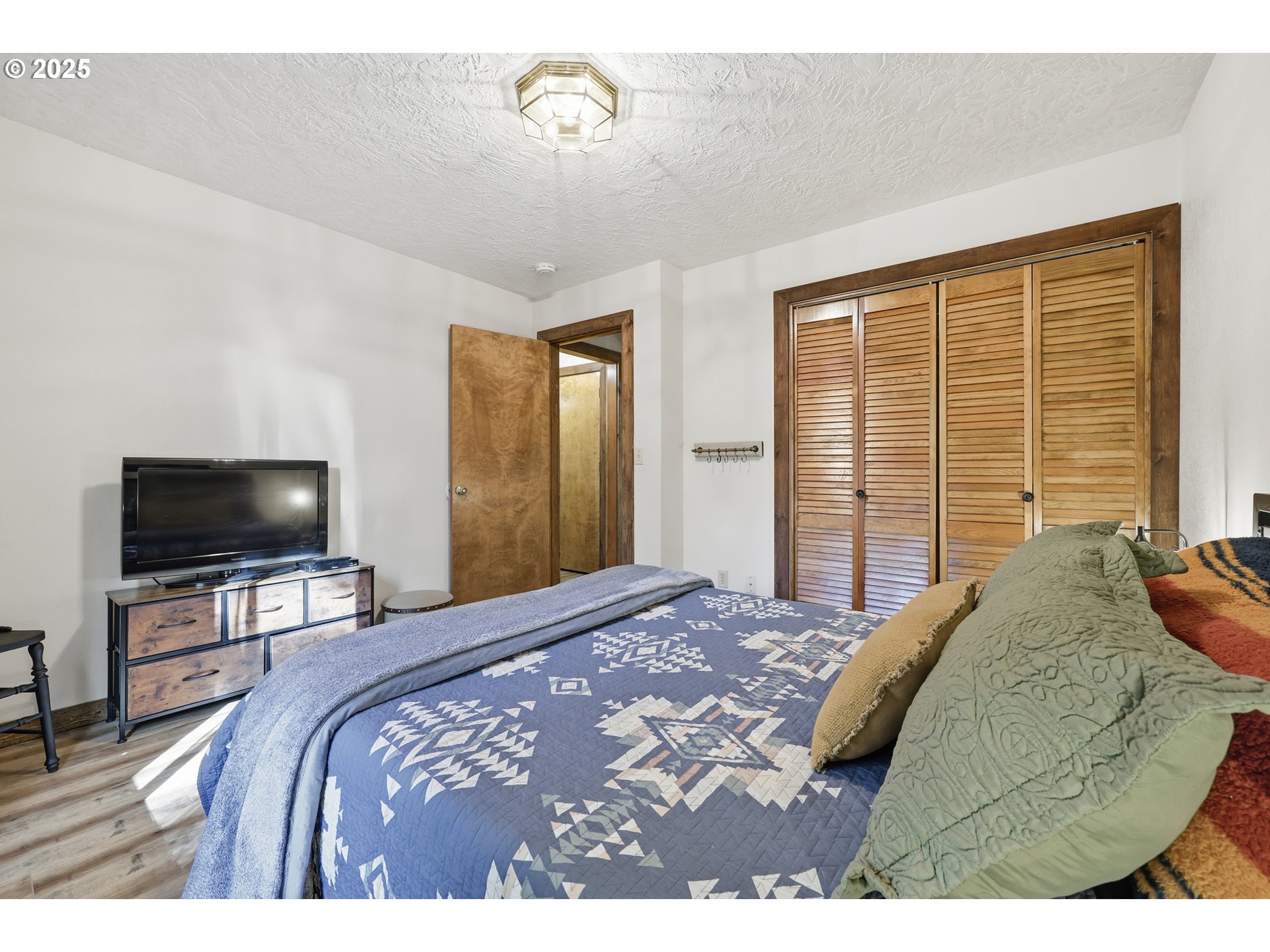65582 East Timberline Drive Rhododendron, OR 97049 - Photo 19 of 47 a bedroom with a bed television on desk and a window