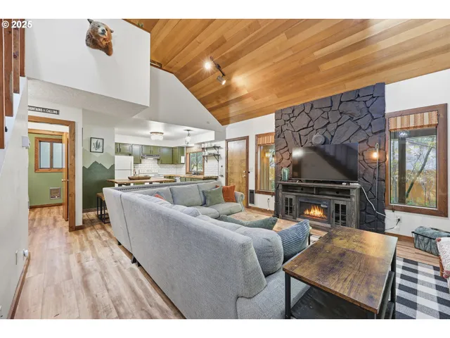 a living room with furniture a flat screen tv and a floor to ceiling window