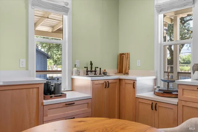 a kitchen with a sink cabinets stainless steel appliances and a window