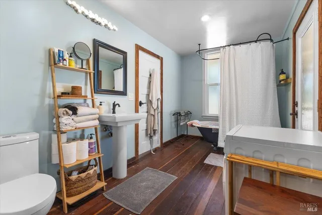 a bathroom with a sink a toilet a mirror and shower