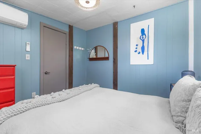 a bedroom with a bed and a wall painting