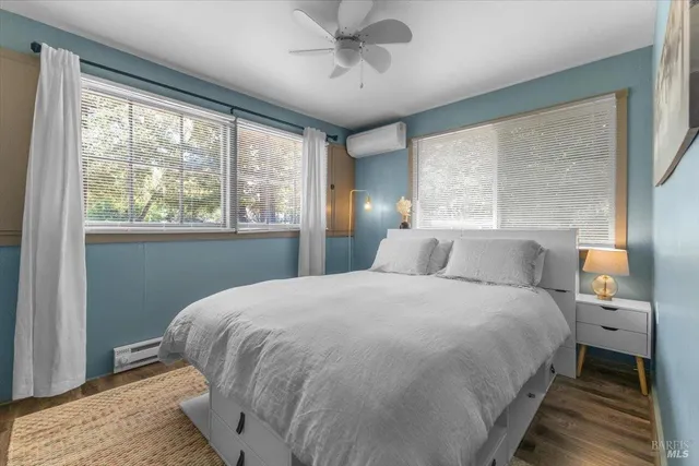 a bedroom with a large bed and wooden floor