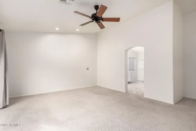 a view of a room with a ceiling fan and window