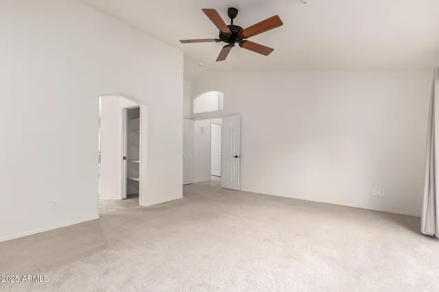 an empty room with a ceiling fan and a window