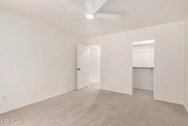 an empty room with a ceiling fan and a window