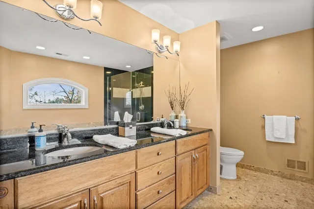 a spacious bathroom with a double vanity sink a large mirror and a shower