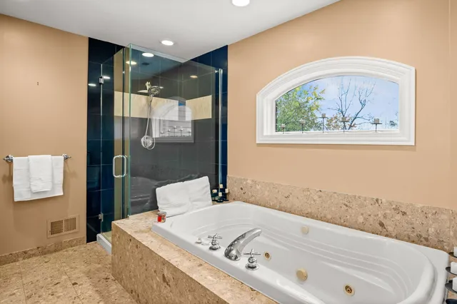 a bathroom with a tub a sink and a window