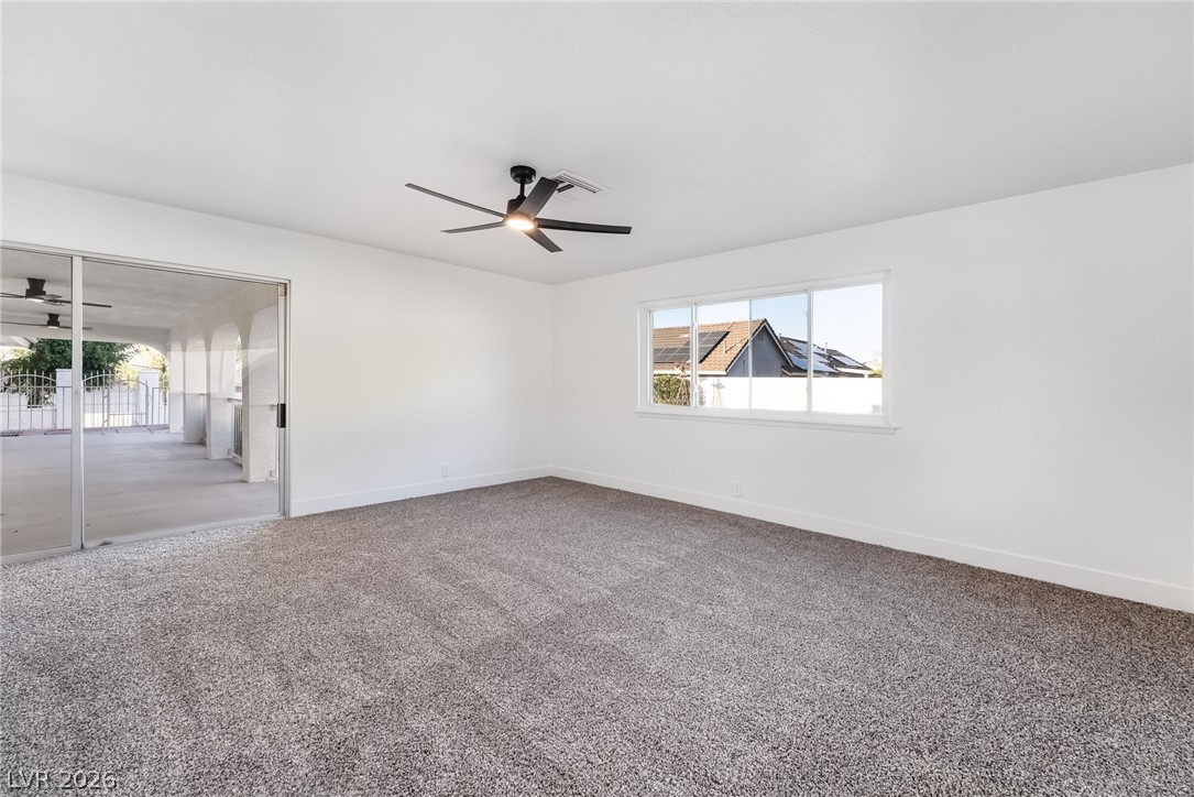 429 Crestway Road Henderson, NV 89015 - Photo 27 of 56 A spacious room offers plush gray carpet, a contemporary ceiling fan, and large windows providing ample natural light.