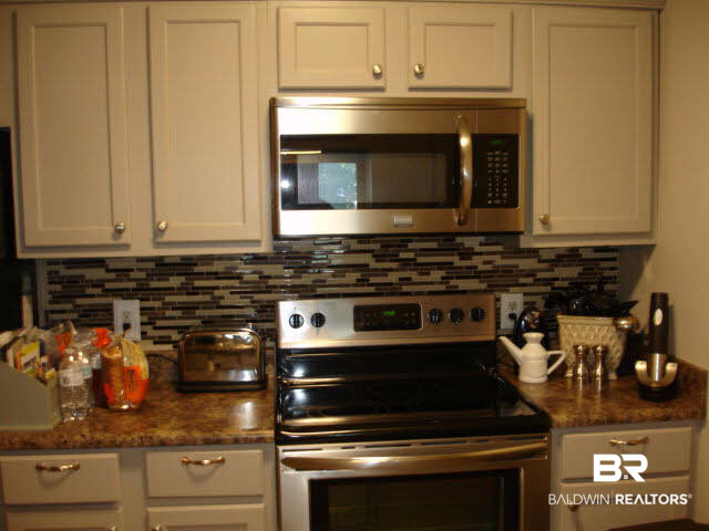 1517 Regency Road, Unit 123 Gulf Shores, AL 36542 - Photo 11 of 31 BEAUTIFUL BACK SPLASH, WITH SMOOTH STAINLESS COOK TOP & MICROWAVE
