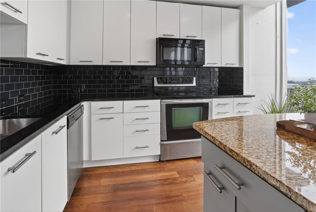 3324 Peachtree Road Northeast, Unit 1312 Atlanta, GA 30326 - Photo 17 of 23 a kitchen with stainless steel appliances granite countertop a sink stove and microwave