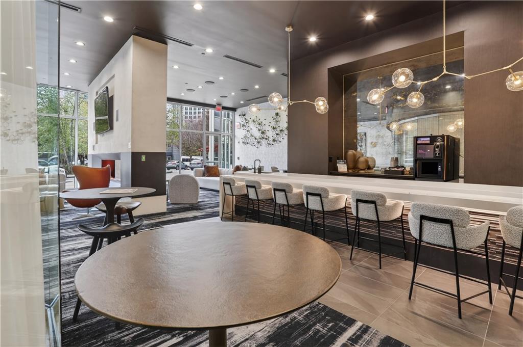 3324 Peachtree Road Northeast, Unit 1312 Atlanta, GA 30326 - Photo 6 of 23 a living room with couches a table and kitchen view with wooden floor