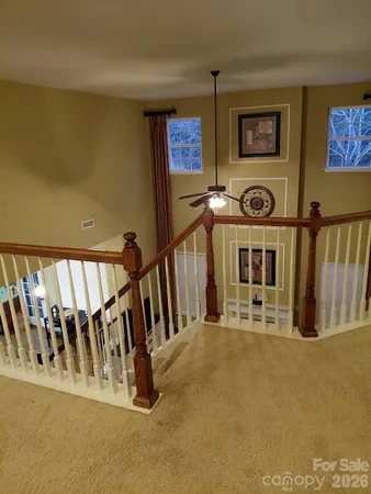 a view of staircase with railing and white walls