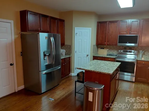 a kitchen with granite countertop wooden cabinets and a sink