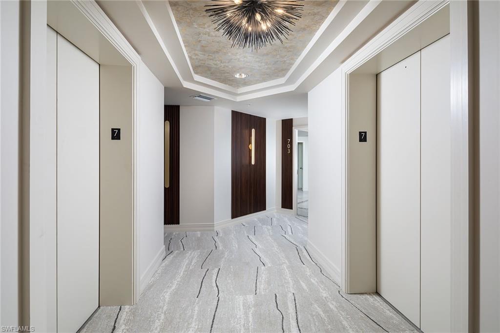 435 Dockside Drive, Unit B703 Naples, FL 34110 - Photo 27 of 38 a view of a hallway with a chandelier fan