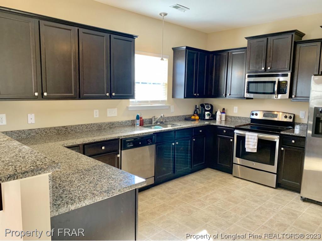 211 Rainmaker Street Linden, NC 28356 - Photo 7 of 34 a kitchen with stainless steel appliances granite countertop a sink stove and microwave