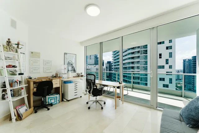 a view of a livingroom with workspace and windows