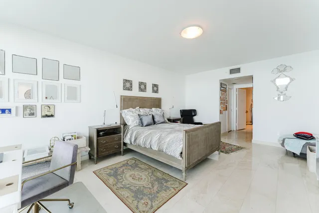 a spacious bedroom with a bed and a desk in it