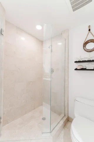 a bathroom with a shower a toilet and a sink