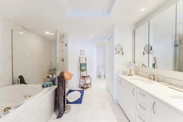 a bathroom with a tub sink and mirror