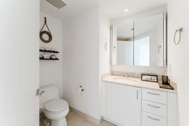 a bathroom with a granite countertop sink toilet and a mirror