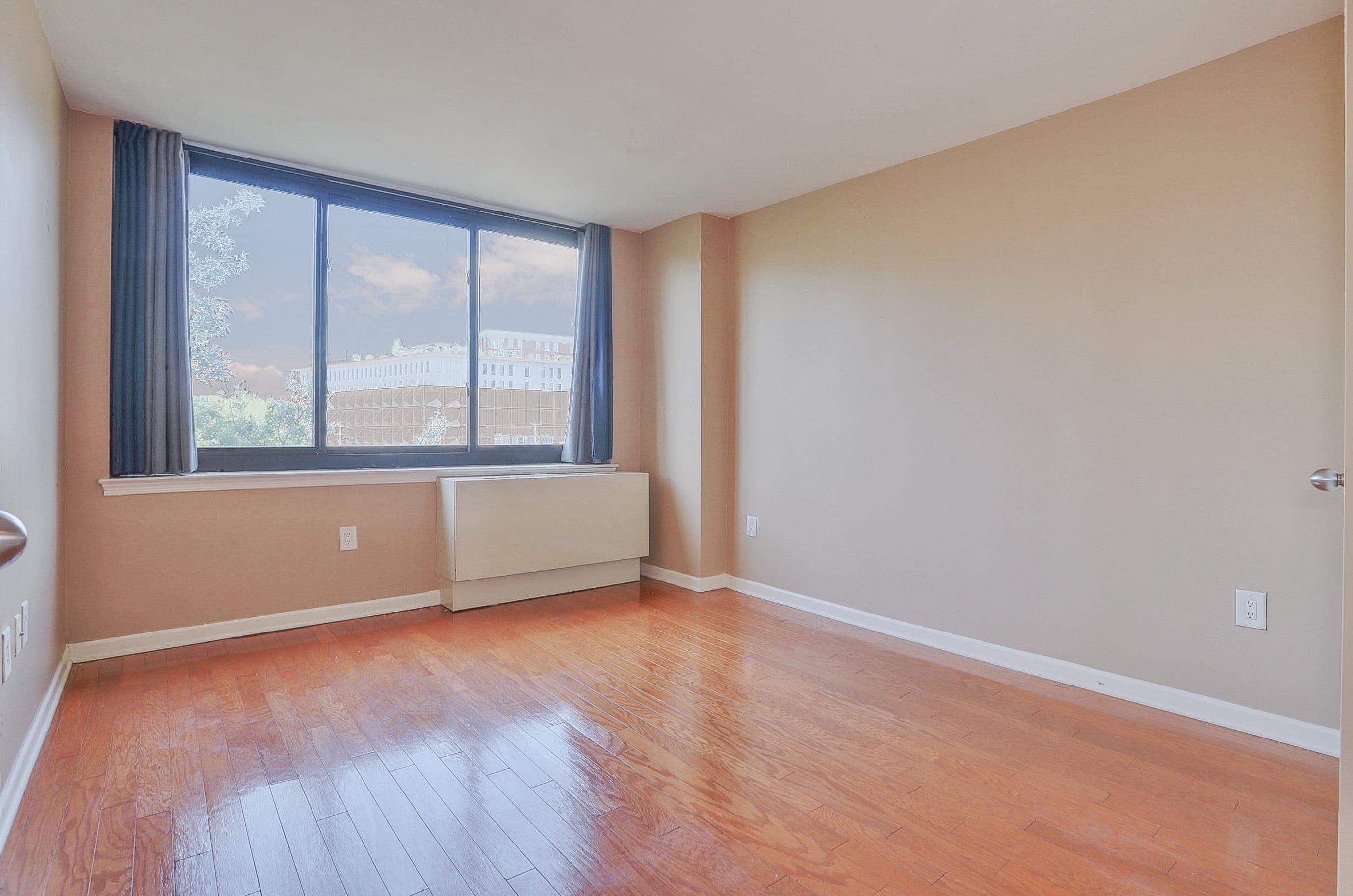 700 Grove Street, Unit 4F Jersey City, NJ 07310 - Photo 13 of 30 an empty room with wooden floor and windows