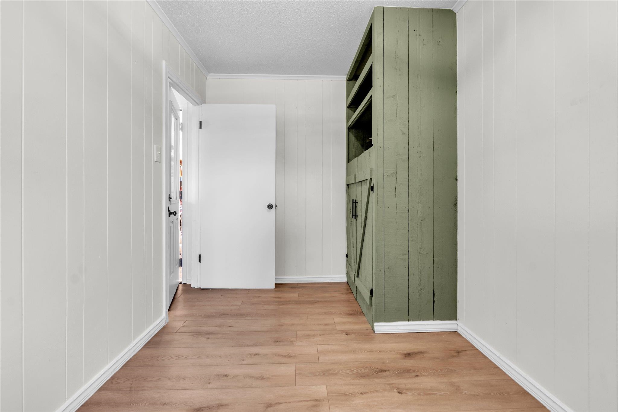 885 Rebel Road Piperton, TN 38017 - Photo 19 of 30 Corridor with light wood-type flooring, wooden walls, crown molding, and a textured ceiling