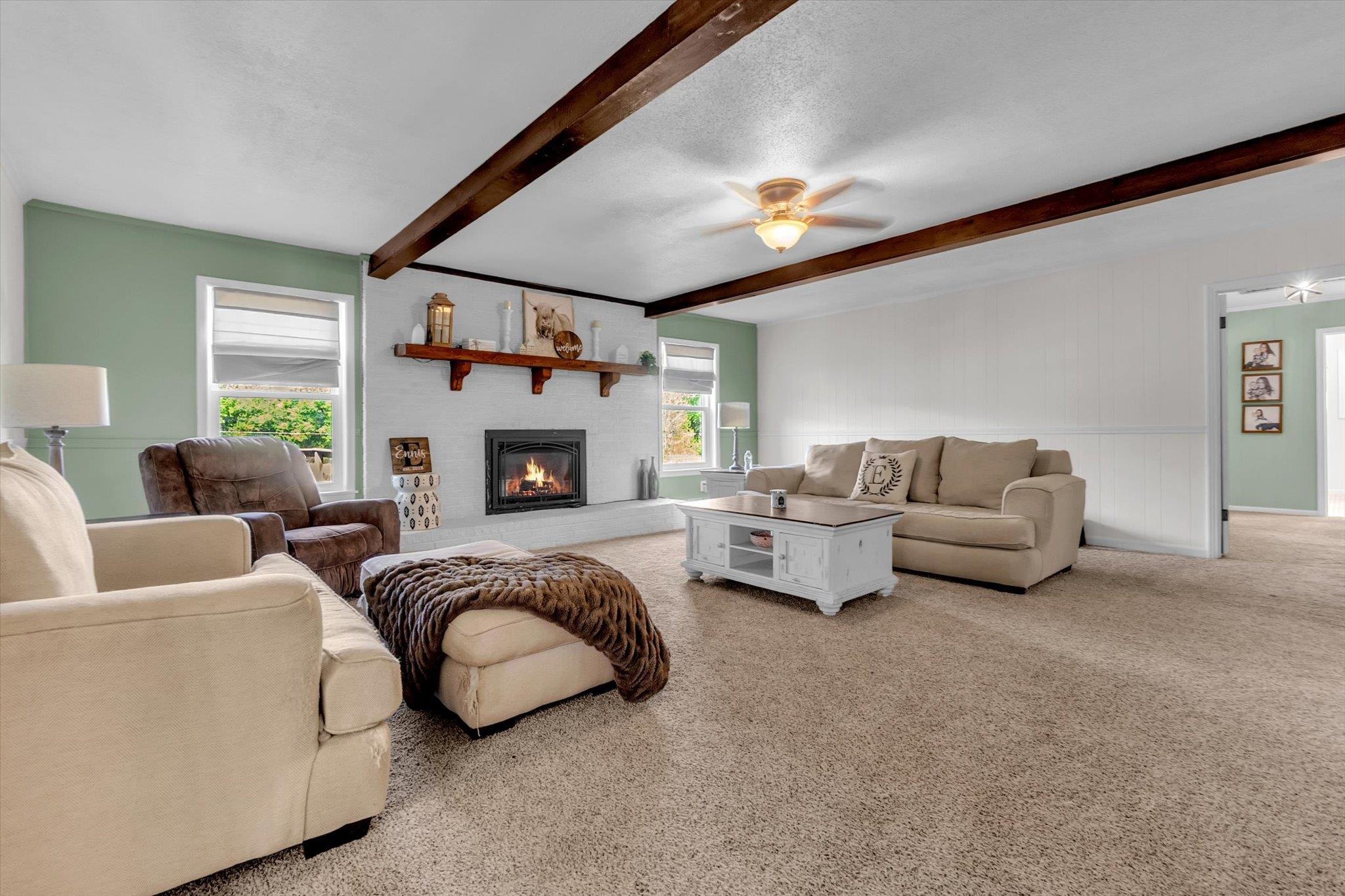 885 Rebel Road Piperton, TN 38017 - Photo 6 of 30 Carpeted living area with ceiling fan, a brick fireplace, beam ceiling, and a textured ceiling