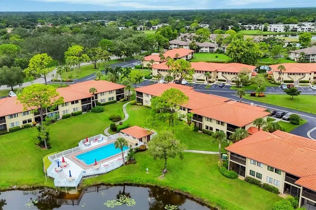 a view of a big house with a big yard and large trees
