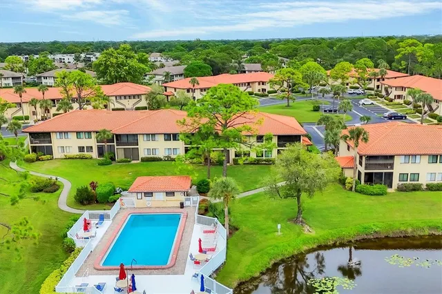 a view of a big house with a big yard plants and large trees